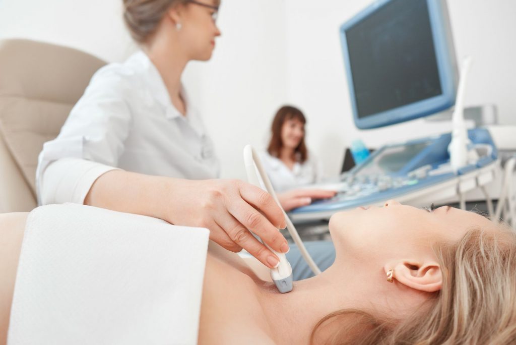 Una endocrinólogo tomando un ultrasonido de tiroides